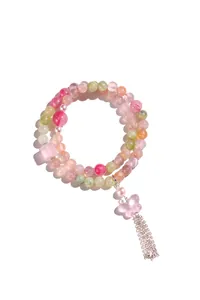Dettaglio del bracciale a doppio filo in cristallo rosa con ciondolo a farfalla.