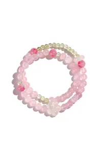 Primo piano di un bracciale a doppio filo in perle di quarzo rosa con charm a fiore