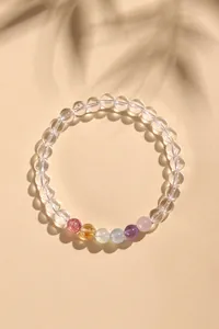 Elegante Draufsicht auf ein Bergkristall-Perlenarmband mit bunten Edelsteinen und Schatten