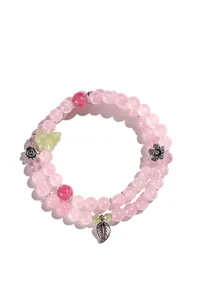 Dettaglio del bracciale a doppio filo in quarzo rosa con ciondoli a farfalla e foglia