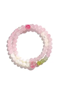 Vista macro dettagliata di un bracciale a doppio giro in quarzo rosa e perle di conchiglia.