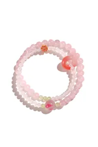 Dettaglio ravvicinato di un dolce bracciale a doppio filo in cristallo rosa e agata bianca