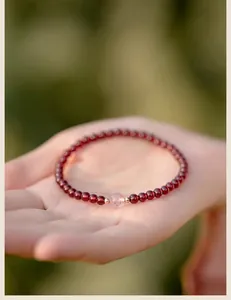Λεπτομέρεια βραχιολιού από φυσικό γρανάτη με κεντρική χάντρα από χαλαζία φράουλας