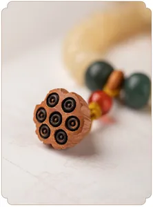 Detailaufnahme eines handgeschnitzten hölzernen Lotus-Anhängers an Bodhi-Gebetsperlen