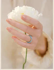 Close-up of a 2mm turquoise beaded ring with a 14k gold accent on a hand