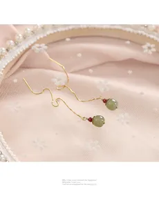 Detailed close-up of elegant green Hetian jade bead ear threads with 14k gold chain