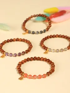 Detailansicht von Holzperlenarmbändern mit Edelsteinen und Anhängern im Detail
