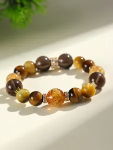 Détail des perles naturelles d'œil de tigre et de citrine avec séparateurs dorés.