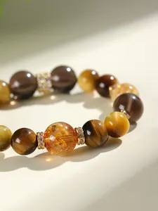 Détail macro de perles d'oeil de tigre et cristal jaune avec séparateurs de cristaux fins