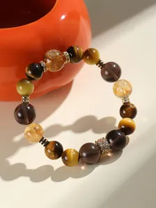 Vue détaillée d'un bracelet en œil de tigre naturel et citrine avec accents dorés