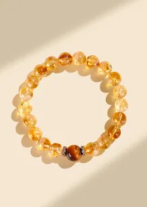 Détail macro d'un bracelet en citrine naturelle avec une perle centrale en oeil de tigre