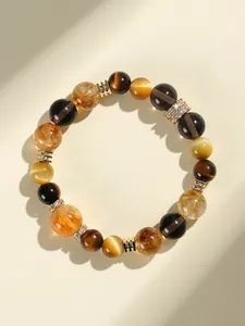 Gros plan d'un bracelet en perles de pierres précieuses avec œil de tigre et éclats d'or