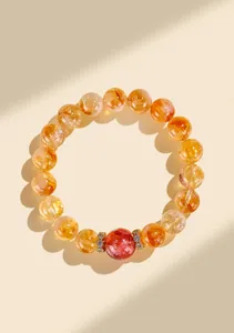 Gros plan détaillé d'un bracelet en perles de citrine jaune naturelle avec une perle rouge