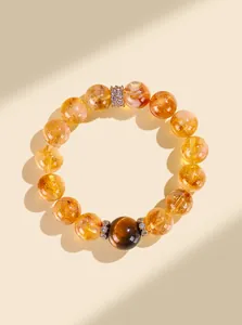 Gros plan d'un bracelet en cristal jaune avec perle d'œil de tigre et entretoises