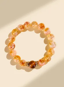 Détail d'un bracelet en perles de citrine jaune naturelle avec œil de tigre et entretoises dorées