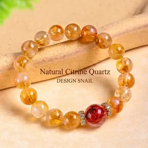 Bracelet en citrine naturelle avec pierre centrale rouge et perles d'espacement dorées