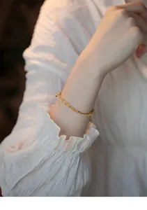 Detail view of dainty 14k gold bracelet with citrine and rutilated quartz on wrist