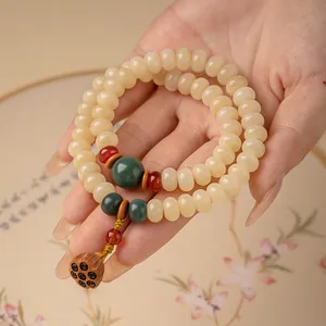 Handgemaakte crèmegele bodhi-wortel armband met lotusvruchtbedel en abacuskralen