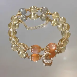 Detailopname van citrien en zonnesteen armband met 14k goudgevulde maanbedel.