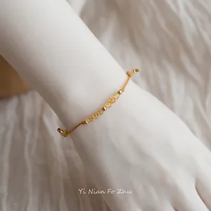 Elegant 14k gold bracelet with citrine and rutilated quartz beads on a woman's wrist