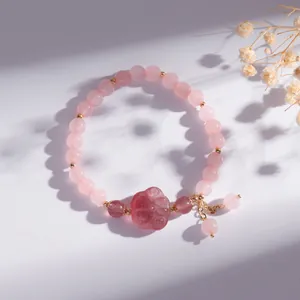 Detailweergave van roze aardbeienkwarts armband met een schattige kattenpoot hanger