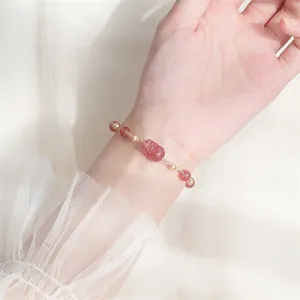 Macro-detail van een natuurlijke aardbeienkwarts armband met gesneden Pixiu-kraal