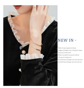 Close-up of an elegant gold-plated layered bracelet with blue beads on a model