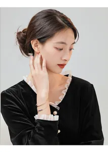 Elegant gold plated bracelet with blue crystal beads shown on female model's wrist