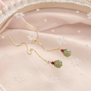 Elegant 14K gold threader earrings featuring natural Hetian jade beads and red accents.