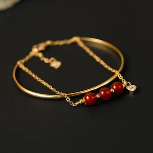 Elegante vergulde armband met natuurlijke rode agaat kralen en een hartvormige hanger