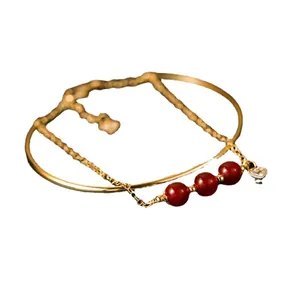 Elegante gouden gelaagde armband met natuurlijke rode agaat kralen en hartvormige hanger