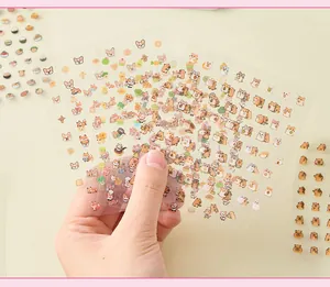 Close-up of hands holding multiple cute cartoon hamster and dog transparent sticker sheets