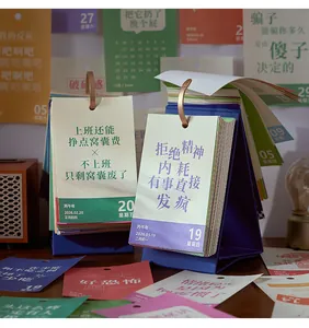 Close-up of a 2026 tear-off desk calendar with humorous Chinese quotes and blue stand