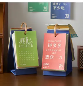 Close-up of 2026 desktop calendars with colorful pages and creative daily quotes.