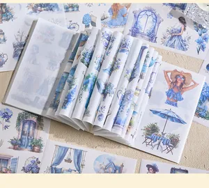 Close-up of blue watercolor sticker book showing aesthetic scenery and lifestyle patterns