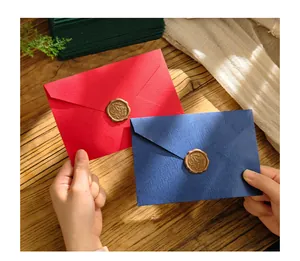 Dettaglio di buste vintage rosse e blu con eleganti sigilli in ceralacca su carta strutturata