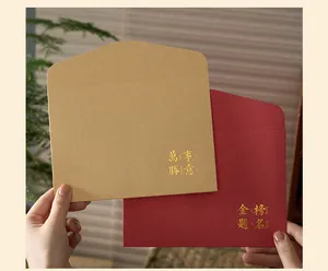 Close-up of kraft and red envelopes with elegant gold foil blessings text.