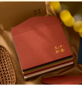 Close-up of gold foil 'Happy Birthday' stamping on a stack of colorful envelopes