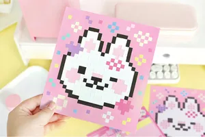Detail view of a cute rabbit pixel art sticker held by hand on a clean workspace