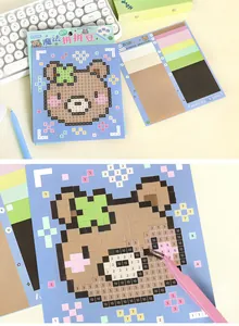 Close-up macro detail of cute animal pixel art bear sticker DIY kit using pink tweezers
