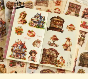 Macro view of vintage girl and strawberry themed stickers in a decorative handbook