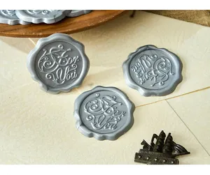 Macro detail of vintage silver wax seal stickers featuring a For You 3D relief pattern