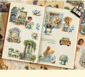 Detailed view of watercolor stickers with pastoral scenes and floral motifs in a journal
