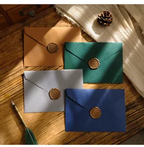 Buste vintage con sigilli di cera in diversi colori su un tavolo di legno antico
