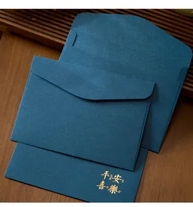 Close-up detail of elegant dark blue envelopes featuring gold foil stamped blessing text