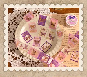 Detail von Vintage-Schmetterlings-Washi-Tape mit Goldfolien-Stempeldesign auf einem Teller.