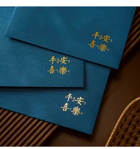 Detail view of deep teal envelope featuring elegant gold-stamped Chinese blessing calligraphy