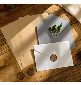 Set di cancelleria vintage con carta da lettere kraft ed eleganti buste su tavolo di legno