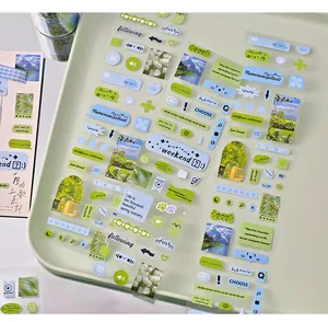 Close-up of green and blue aesthetic decorative sticker sheets for DIY journaling and scrapbooking