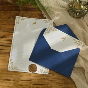 Set di carta da lettere retrò e busta blu marina con sigillo in cera su fondo legno